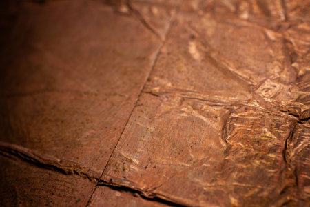 Extreme closeup of crumpled brass foil texture. Selective soft focus, shallow depth of field.の写真素材