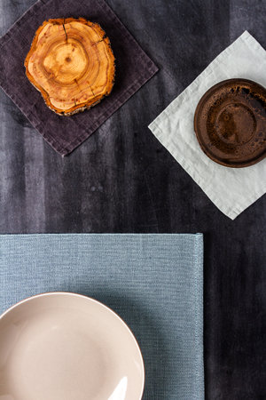 Various objects and table cloths on black chalkboard background. Flat lay. Top view.