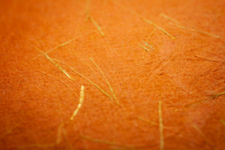 Extreme closeup of orange handmade paper with shallow depth of field.の写真素材