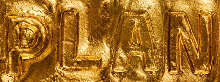 Word plan made of gold foil close-up. Abstract background.の写真素材