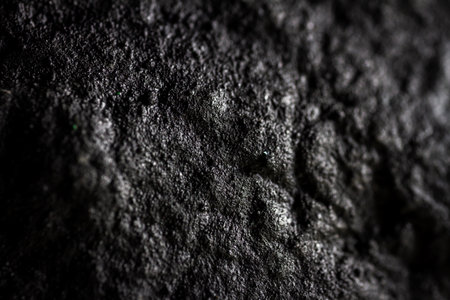 Extreme close up of painted in black handmade paper clay with a structure and rough texture. Paper...