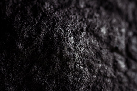 Extreme close up of painted in black handmade paper clay with a structure and rough texture. Paper recycling. Selective focus, shallow depth of field.の写真素材