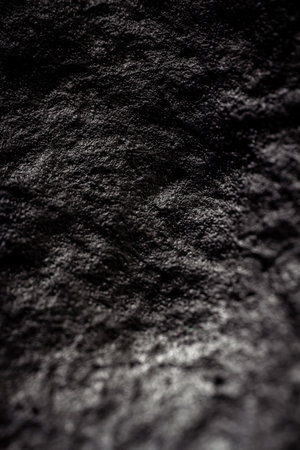 Extreme close up of painted in black handmade material with a structure and rough texture. Selective...