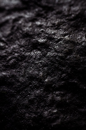 Extreme close up of painted in black handmade paper clay with a structure and rough texture. Paper recycling. Selective focus, shallow depth of field.の写真素材