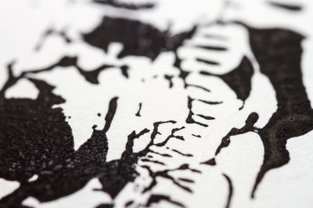 Extreme close up of black acrylic paint texture on paper. Selective focus.