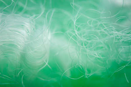 Extreme macro of polyester stable fiber on green background. Selective focus, shallow depth of...