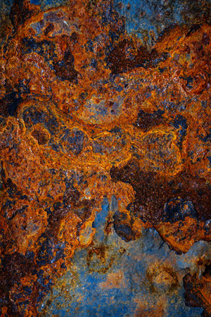 Rusty metal surface with shabby background paint. Blue cracked paint texture on an iron sheet....
