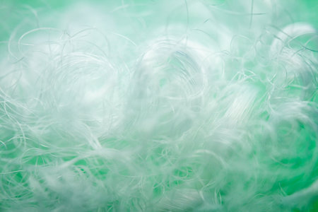 Extreme macro of polyester stable fiber on green background. Selective focus, shallow depth of field. Abstract dreamy backgroundの写真素材