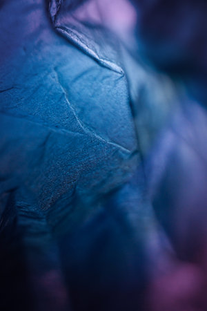 Extreme close up of blue empty plastic bag background. The plastic surface is wrinkly and tattered making abstract pattern. Selective focus, shallow depth of field.の写真素材