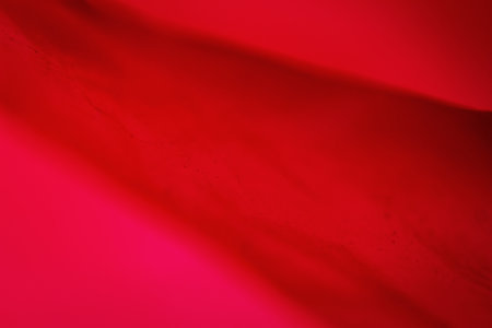 Extreme close up of red empty plastic bag background. The plastic surface is wrinkly and tattered making abstract pattern. Selective focus, shallow depth of field.の写真素材
