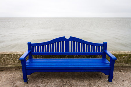 Lonely blue bench on a concrete pier under a cloudy sky in Nida Lithuaniaの写真素材