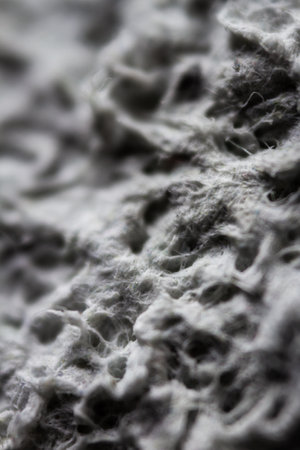 Extreme close up of old gray handmade paper clay with a structure and rough texture. Paper recycling. Selective soft focus, shallow depth of field.の写真素材