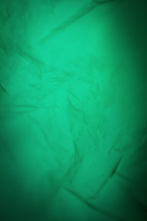 Extreme close up of green empty plastic bag background. The plastic surface is wrinkly and tattered making abstract pattern. Selective focus, shallow depth of field.の写真素材
