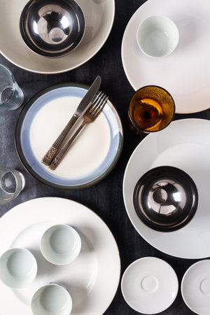 Top view of an empty plates, bowls, glasses and cutlery placed on a black chalkboard background. Flat lay. Top view. Food concept.の写真素材