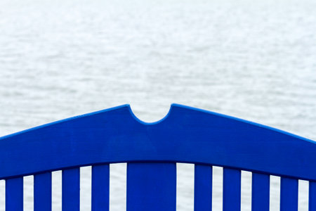 Part of blue bench on a concrete pier under a cloudy sky in Nida, Lithuaniaの写真素材