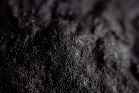 Extreme close up of painted in black handmade paper clay with a structure and rough texture. Paper recycling. Selective focus, shallow depth of field.の写真素材