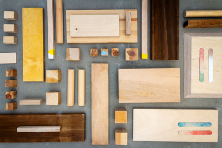 Flat lay of various wood and plywood pieces on concrete texture. Carpentry background.