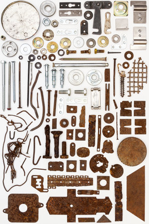 A group of various old and new bits and pieces arranged on white. Old rusty nuts, bolts, nails and...