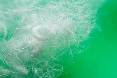 Extreme macro of polyester stable fiber on green background. Selective focus, shallow depth of...