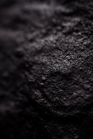 Extreme close up of painted in black handmade paper clay with a structure and rough texture. Paper recycling. Selective focus, shallow depth of field.の写真素材