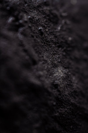 Extreme close up of painted in black handmade paper clay with a structure and rough texture. Paper recycling. Selective focus, shallow depth of field.の写真素材