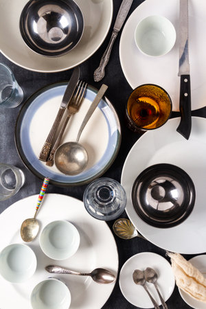 Top view of an empty plates, bowls, glasses and cutlery placed on a black chalkboard background. Flat lay. Top view. Food concept.の写真素材