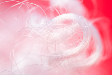 Extreme macro of polyester stable fiber on red background. Selective focus, shallow depth of field. Abstract dreamy backgroundの写真素材