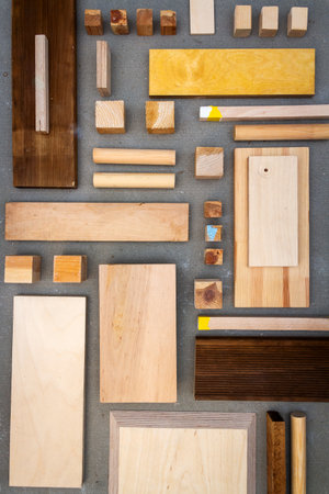 Flat lay of various wood and plywood pieces on concrete texture. Carpentry background.の写真素材