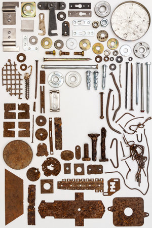 A group of various old and new bits and pieces arranged on white. Old rusty nuts, bolts, nails and...