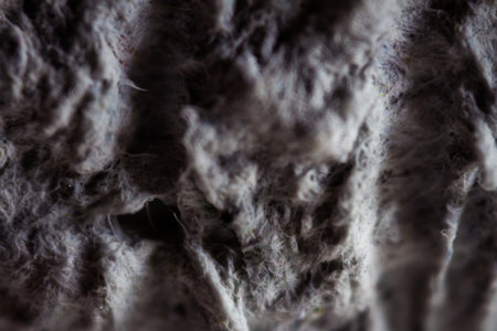 Extreme close up of old gray handmade paper clay with a structure and rough texture. Paper...
