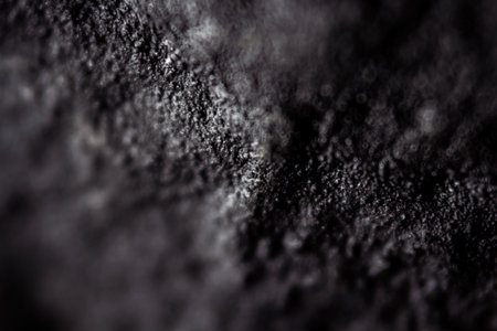 Extreme close up of old black handmade paper clay with a structure and rough texture. Paper recycling. Selective soft focus, shallow depth of field.の写真素材