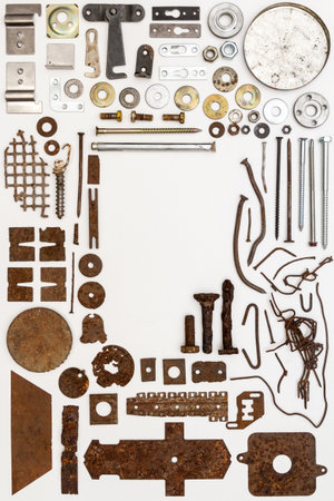 A group of various old and new bits and pieces arranged on white. Old rusty nuts, bolts, nails and other parts flay lay on white background.の写真素材