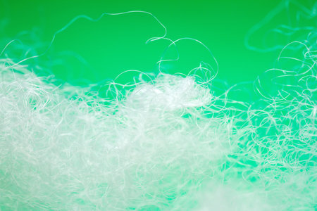 Extreme macro of polyester stable fiber on green background. Selective focus, shallow depth of field. Abstract dreamy backgroundの写真素材