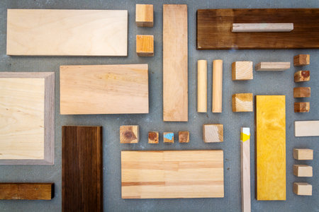 Flat lay of various wood and plywood pieces on concrete texture. Carpentry background.の写真素材