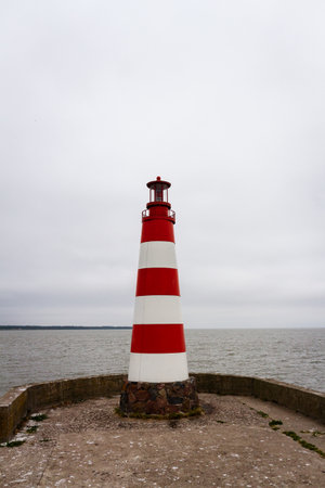 Lighthouse on a concrete pier under a cloudy sky in Nida, Curonian Spit and Curonian Lagoon, Lithuaniaの写真素材