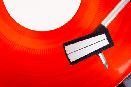 Close up of turntable needle on a record. Turntable playing vinyl. Needle on rotating red disk.の写真素材