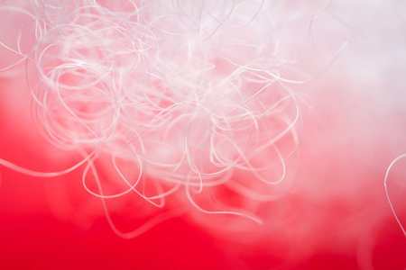 Extreme macro of polyester stable fiber on red background. Selective focus, shallow depth of field. Abstract dreamy backgroundの写真素材