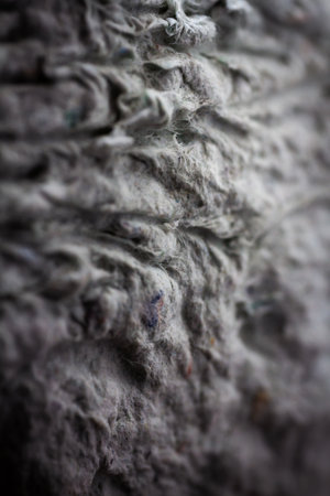 Extreme close up of old gray handmade paper clay with a structure and rough texture. Paper recycling. Selective soft focus, shallow depth of field.の写真素材