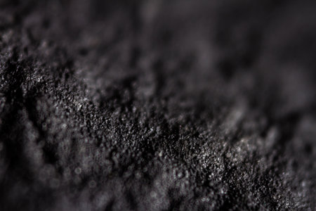 Extreme close up of old black handmade paper clay with a structure and rough texture. Paper recycling. Selective soft focus, shallow depth of field.の写真素材