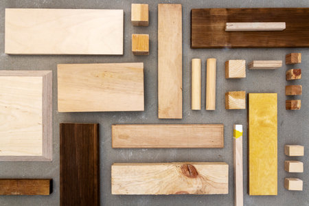 Flat lay of various wood and plywood pieces on concrete texture. Carpentry background.