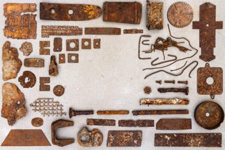 A group of various old rusty bits and pieces arranged on a concrete surface. Old rusty nuts, bolts, nails and other parts flay lay on gray background.の写真素材
