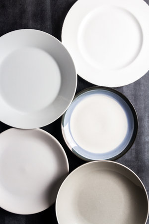 Top view of an empty plates and bowls placed on a black chalkboard background. Flat lay. Food concept.の写真素材