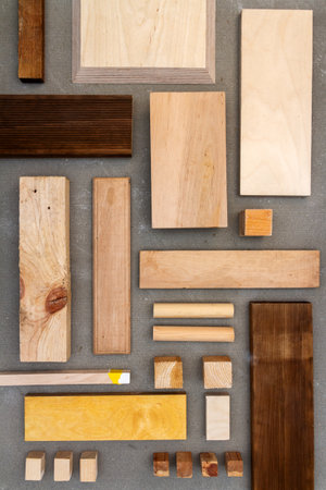 Flat lay of various wood and plywood pieces on concrete texture. Carpentry background.の写真素材