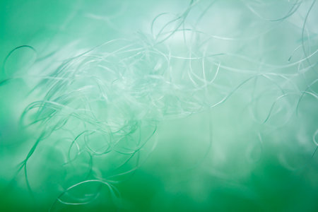 Extreme macro of polyester stable fiber on green background. Selective focus, shallow depth of field. Abstract dreamy backgroundの写真素材