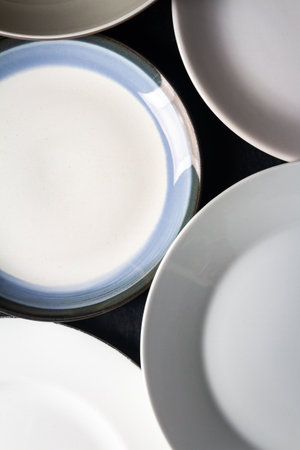 Top view of an empty plates and bowls placed on a black chalkboard background. Flat lay. Top view....
