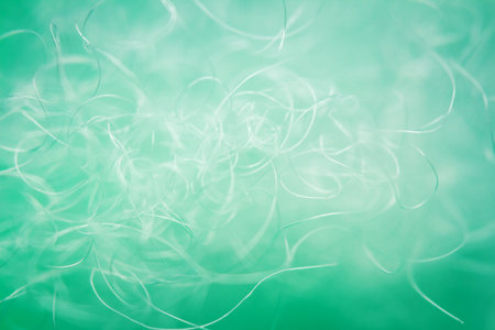 Extreme macro of polyester stable fiber on green background. Selective focus, shallow depth of field. Abstract dreamy backgroundの写真素材