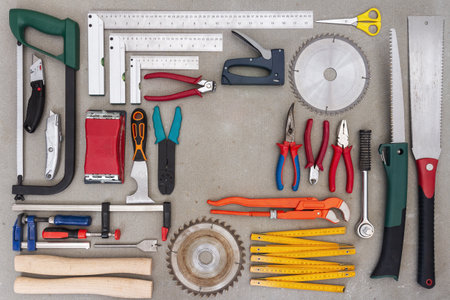 Flat lay of old hand tools on concrete background. Large collection of various rusty tools and bits arranged on concrete.の写真素材
