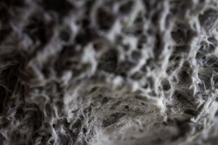 Extreme close up of old gray handmade paper clay with a structure and rough texture. Paper recycling. Selective soft focus, shallow depth of field.の写真素材