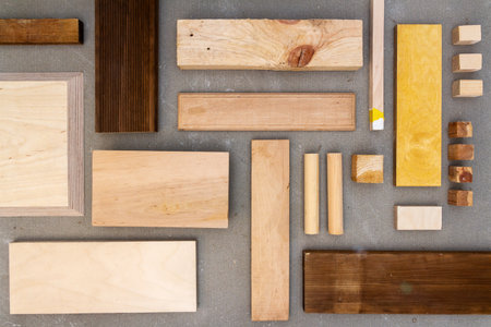 Flat lay of various wood and plywood pieces on concrete texture. Carpentry background.の写真素材