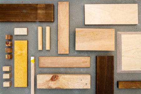 Flat lay of various wood and plywood pieces on concrete texture. Carpentry background.の写真素材